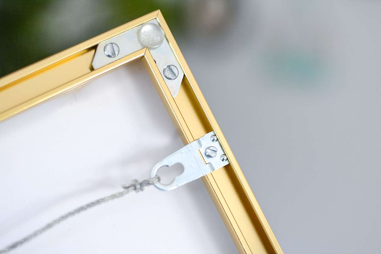 Hanging wire and back of a gold metal frame