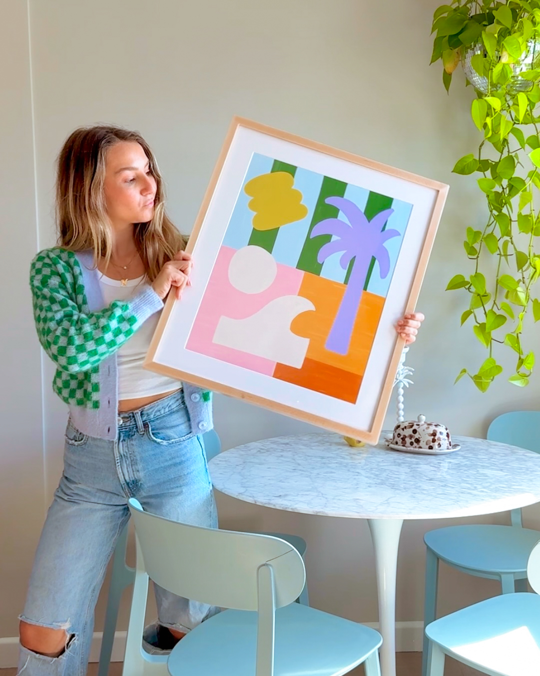 artist holding a picture frame of her art print