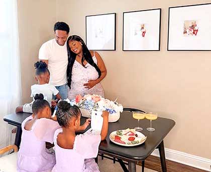 Family at table with frames on wall