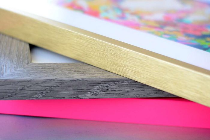 Gold and pink metal picture frames with gray wood picture frame
