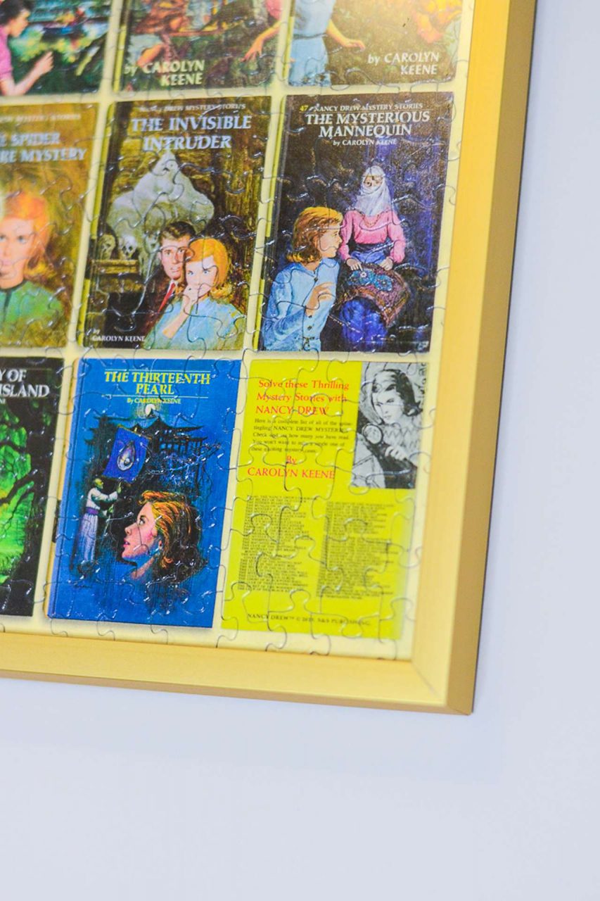 Close-up of gold puzzle frame with Nancy Drew book covers