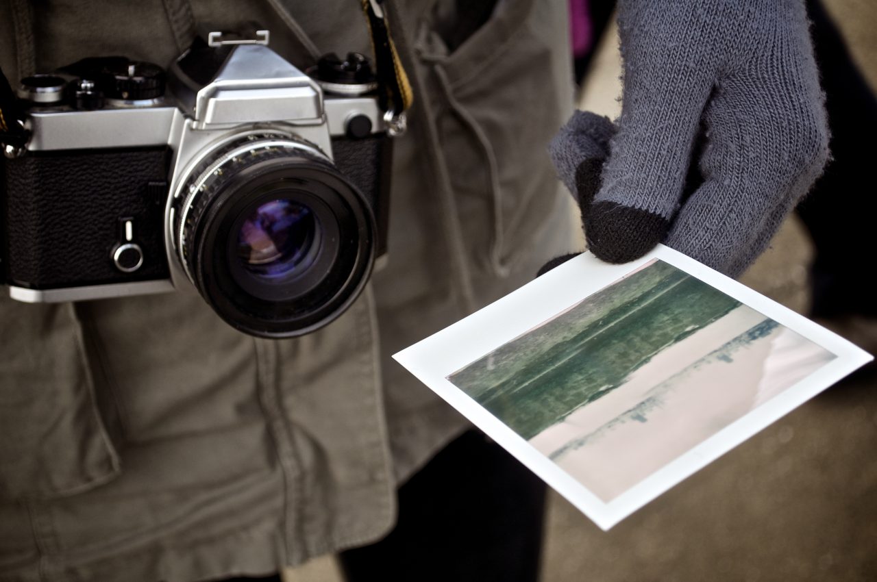 Classic camera with hand holding Polaroid photo