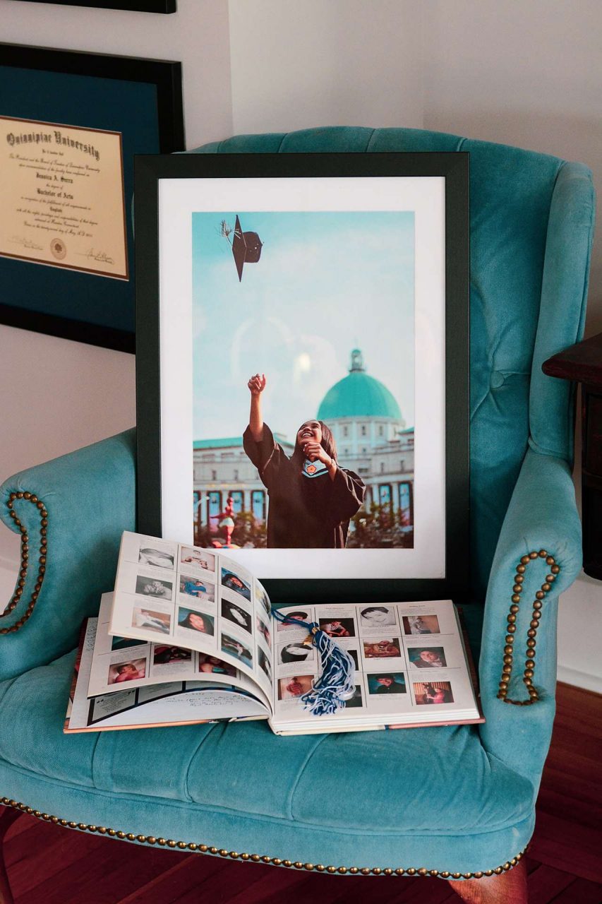 Framed graduation gift photo with yearbook and tassel on chair