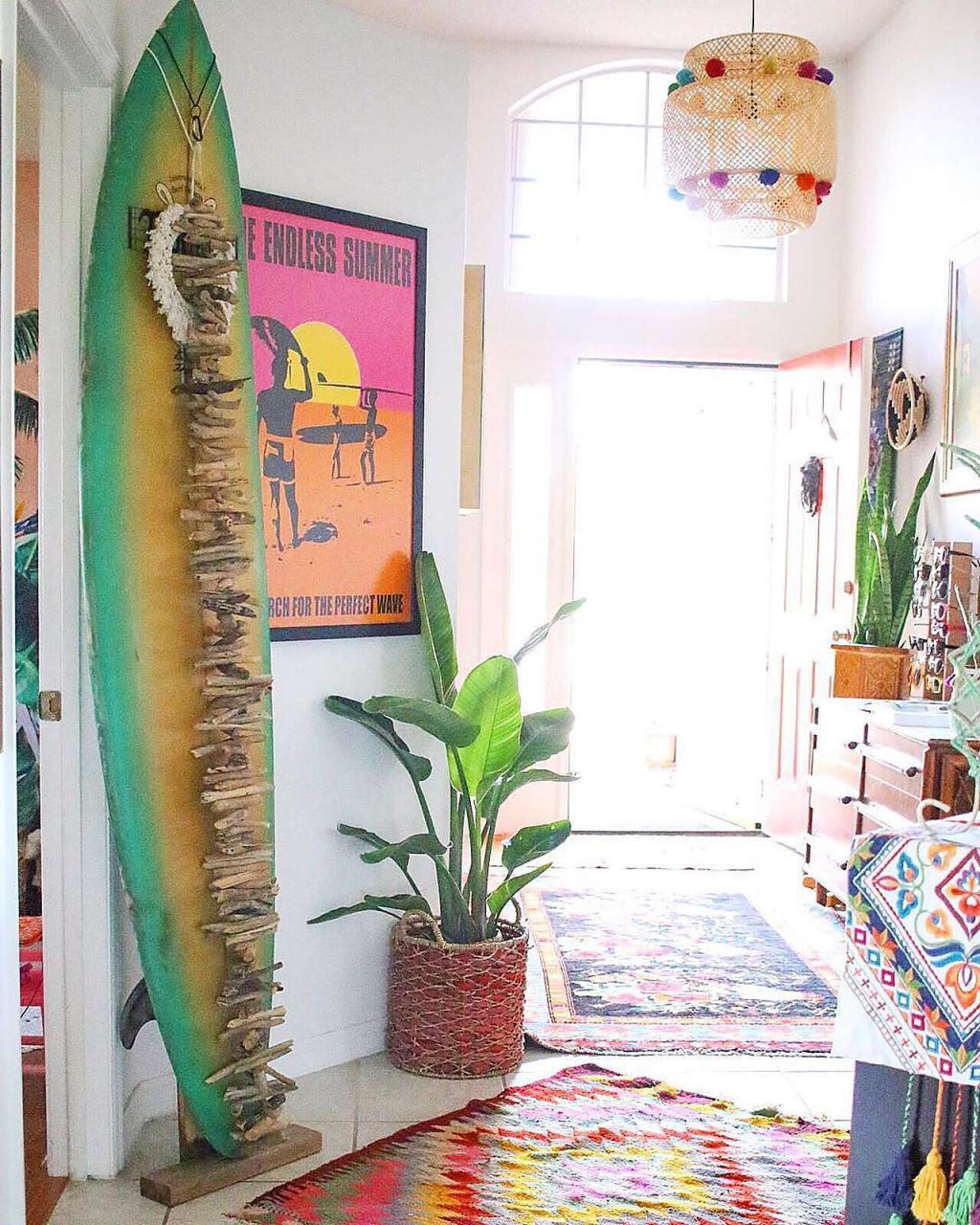 Boho-style hallway with surf board with Endless Summer poster in frame