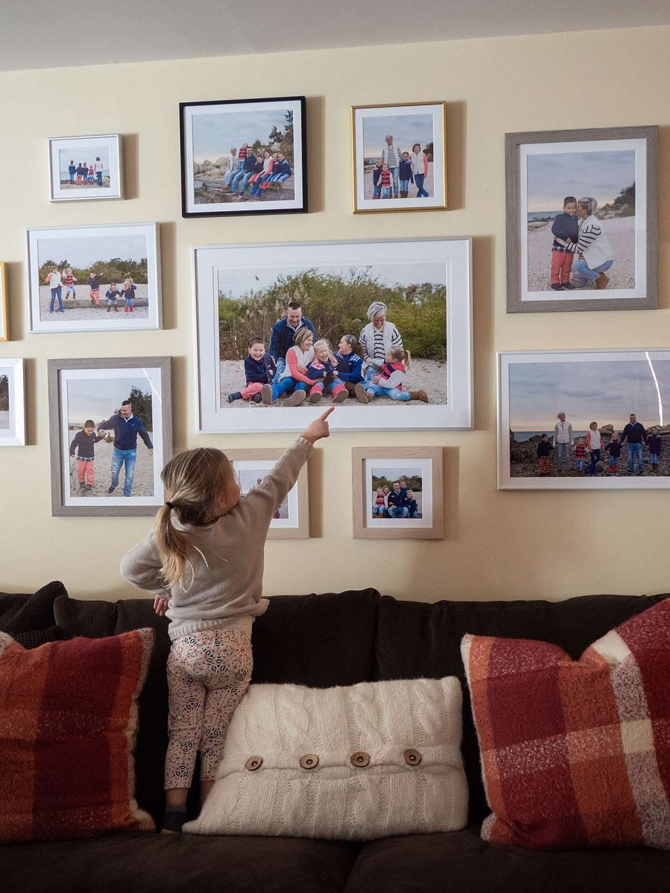 Family gallery wall with small child pointing