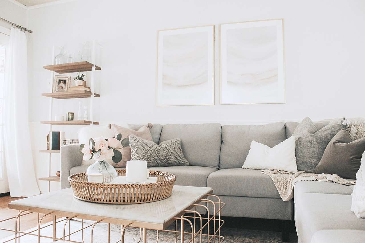 Large gold picture frames in clean, neutral colored living room