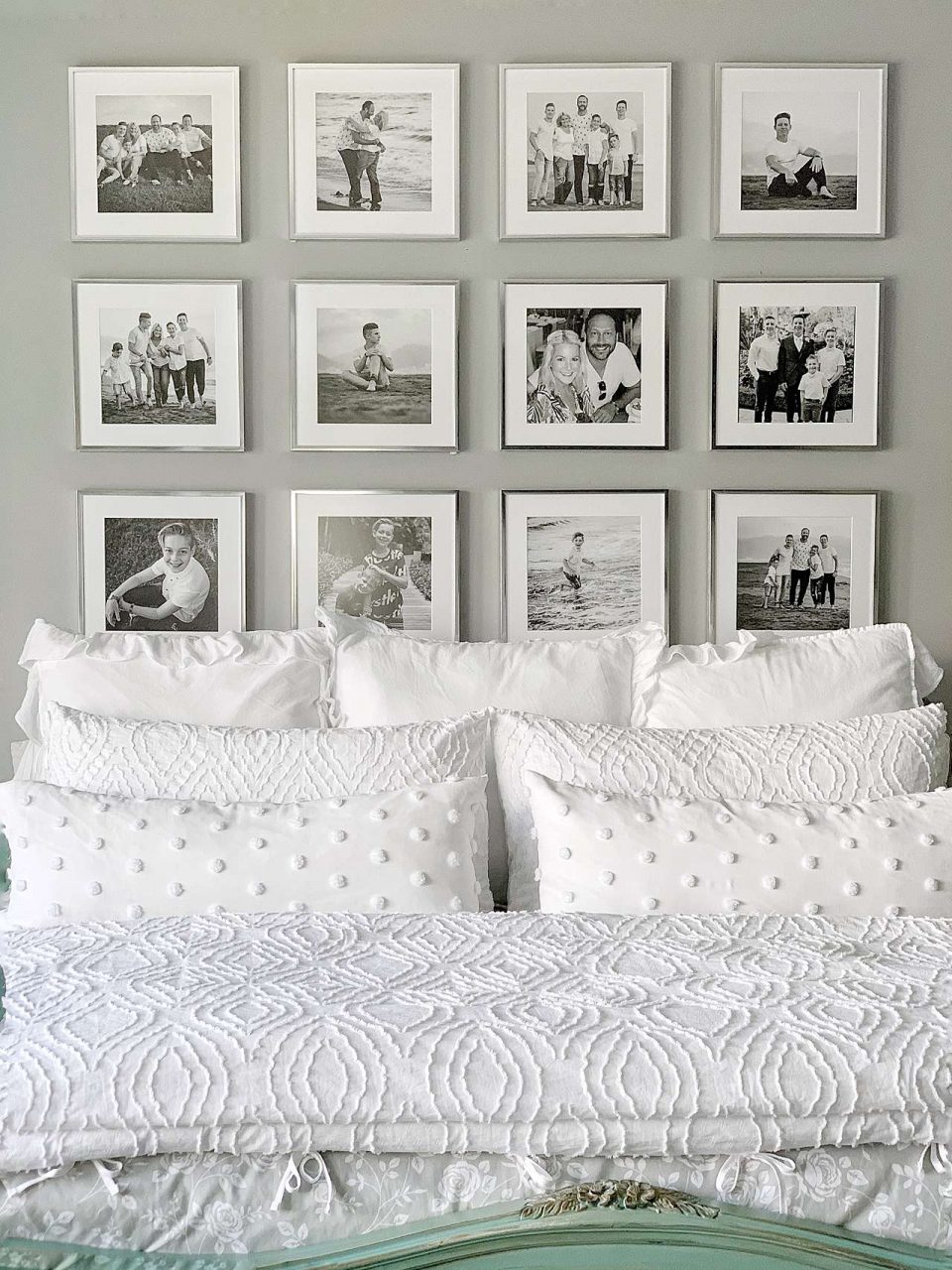 Silver picture frame gallery wall behind white bed