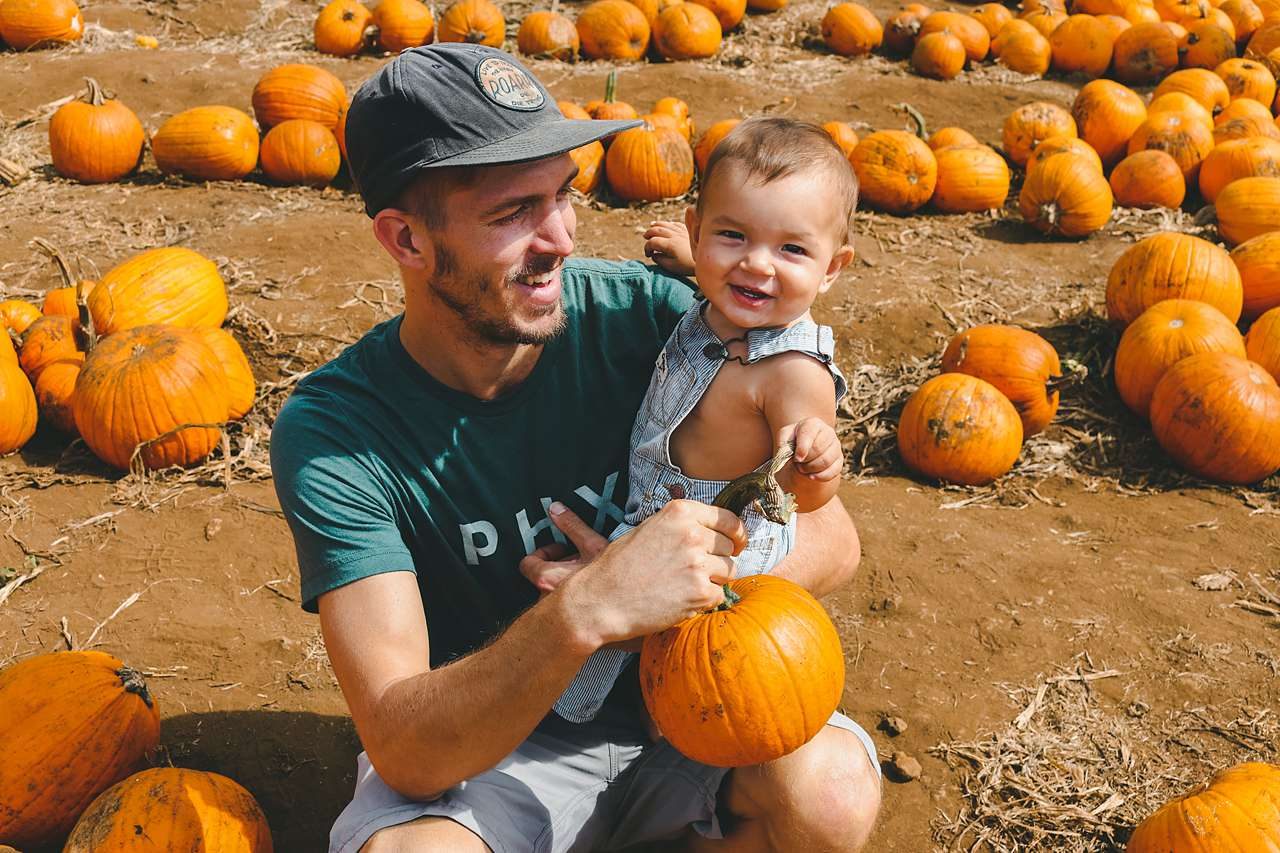 dad and son in pumpkin patch