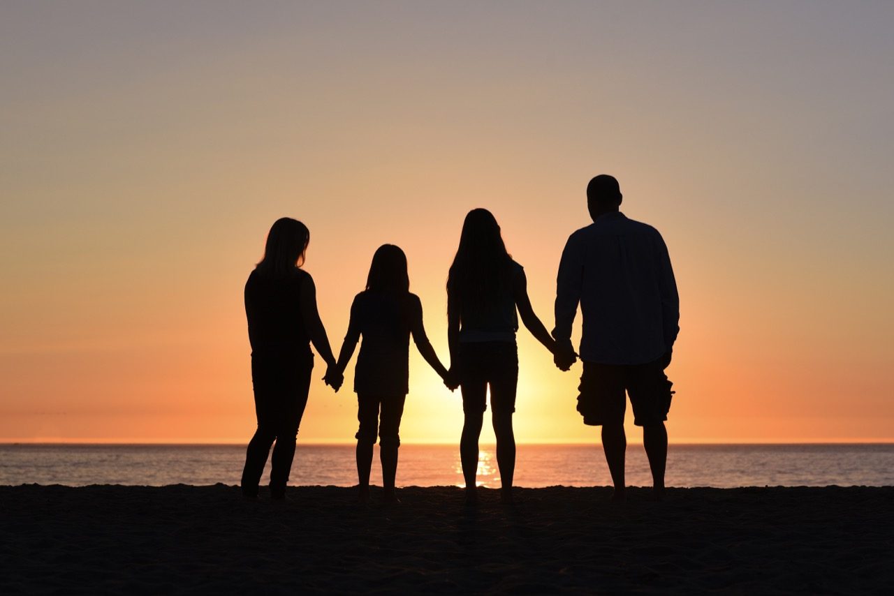 family silhouette on beach