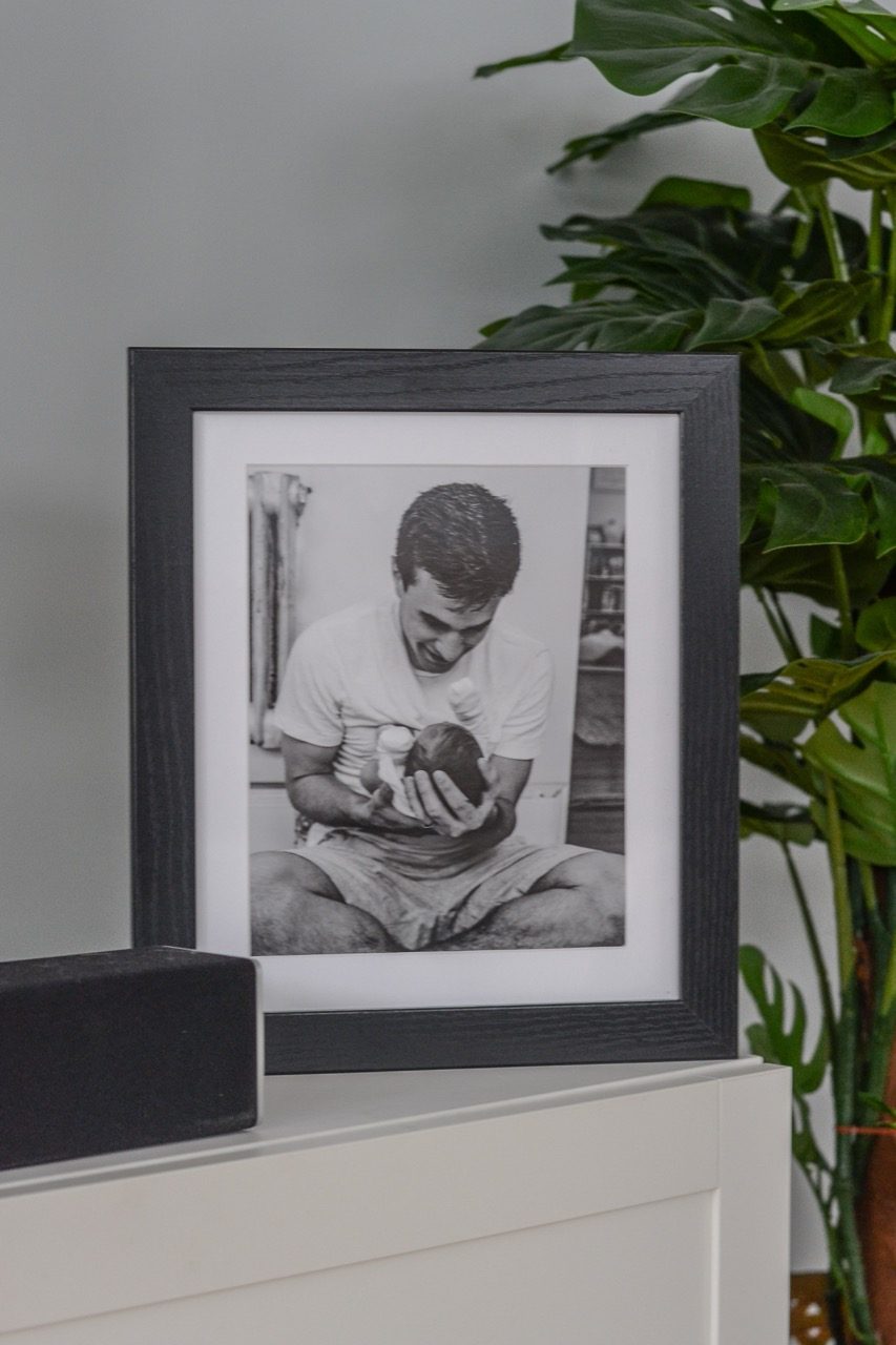 photo of dad holding newborn baby in black picture frame