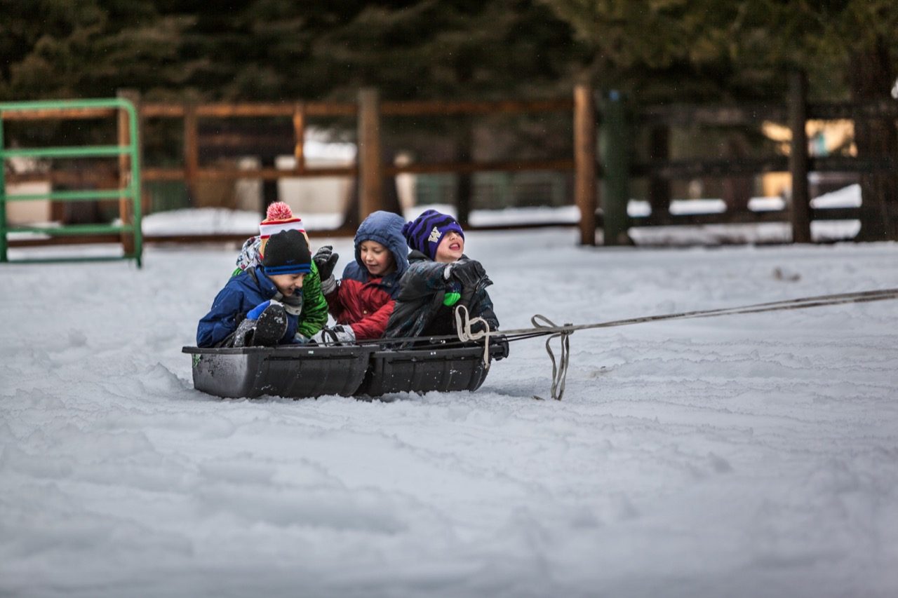 Kids being pulled in a sled. 