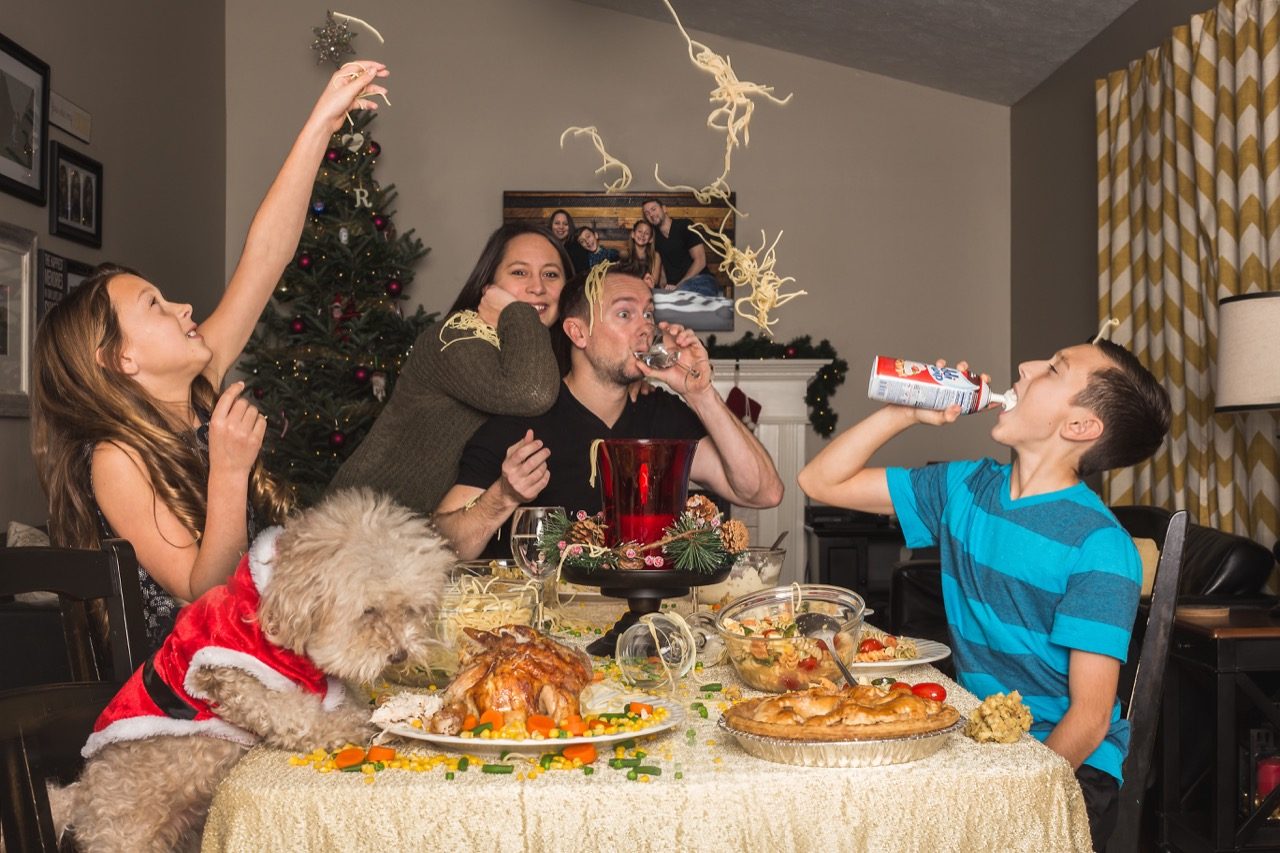 Goofy family holiday photo at dinner table. 