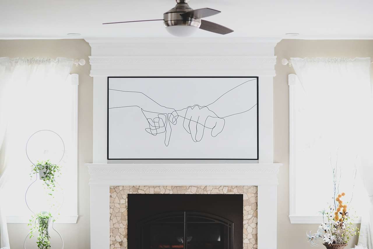 large framed wall piece above fireplace