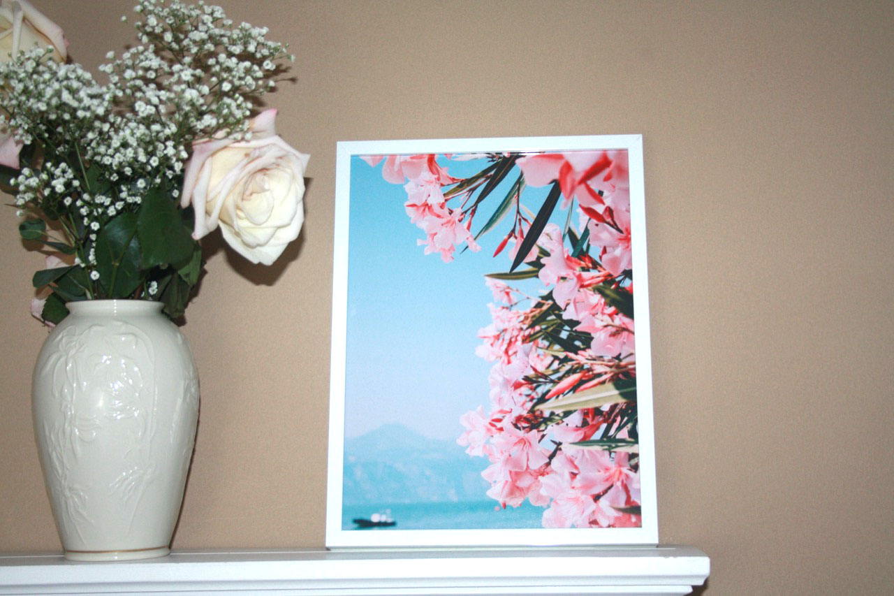 White framed photo on shelf with flowers