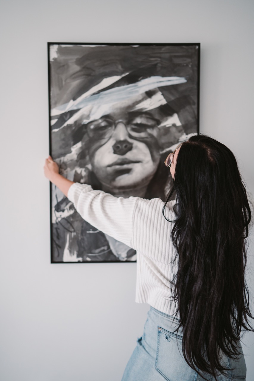 Artist Frames: Celebrating Diversity In The Arts - A woman hanging a frame