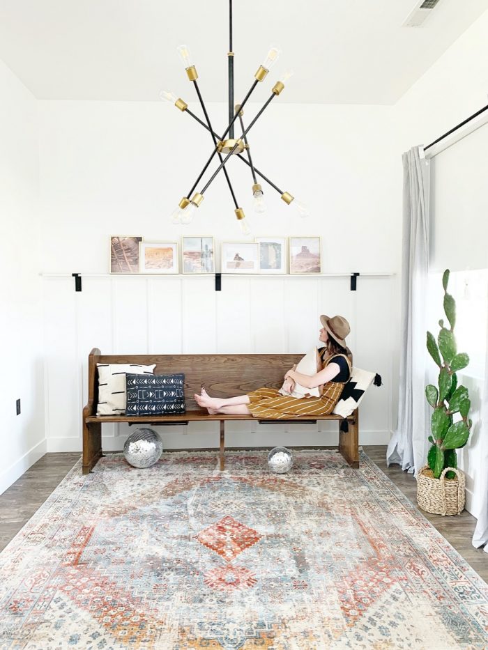 A woman sitting beneath white picture frames 