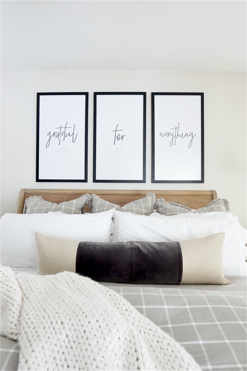 Three large picture frames above bed 
