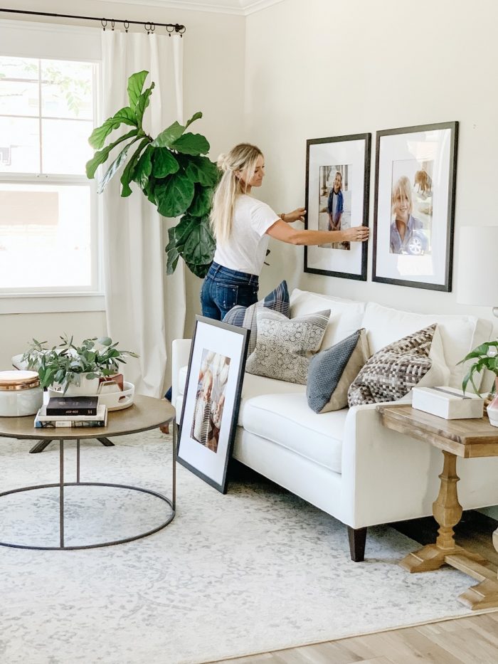 A woman hanging art frames