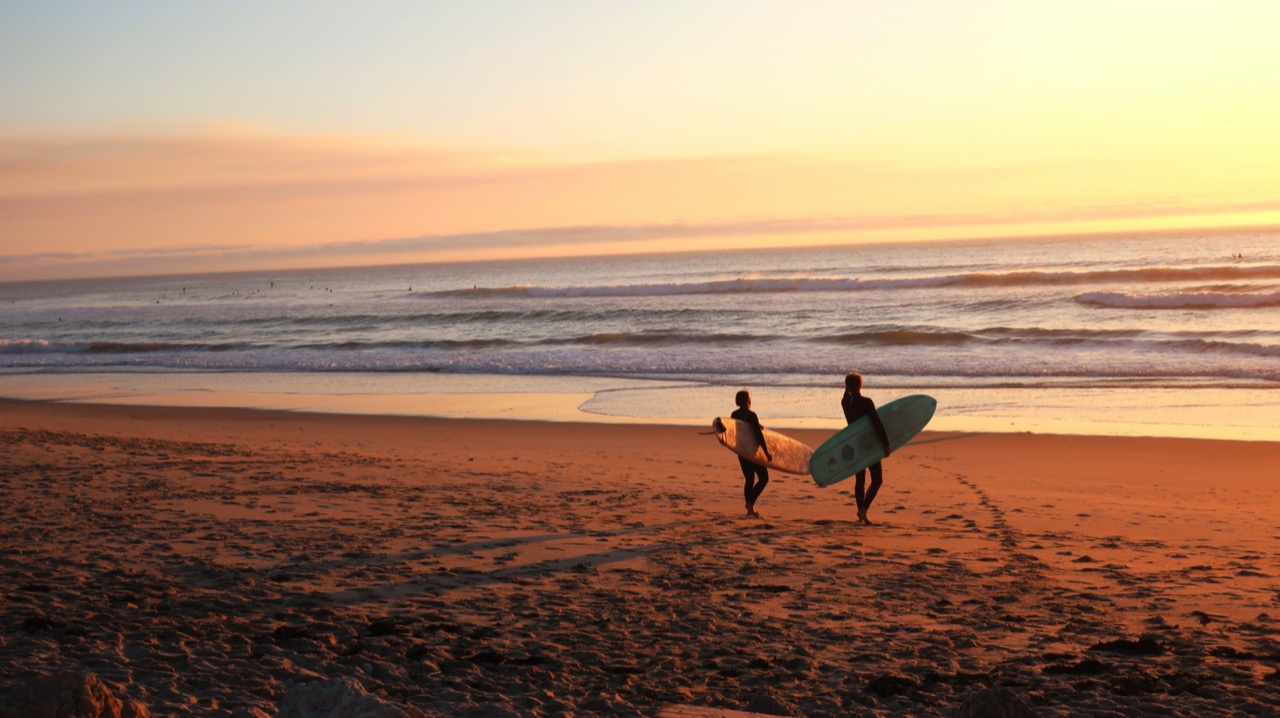 surfers walking to the water 