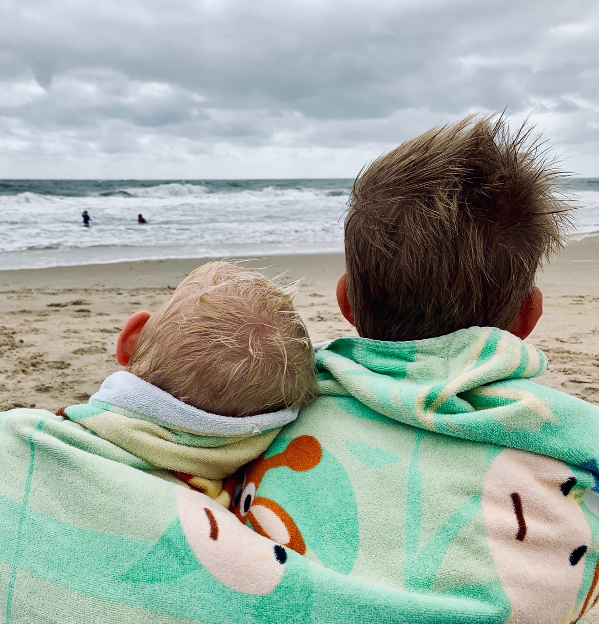 boys sitting on the beach