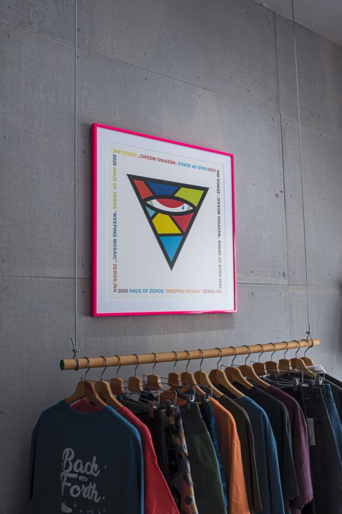 Framed art above a clothing rack