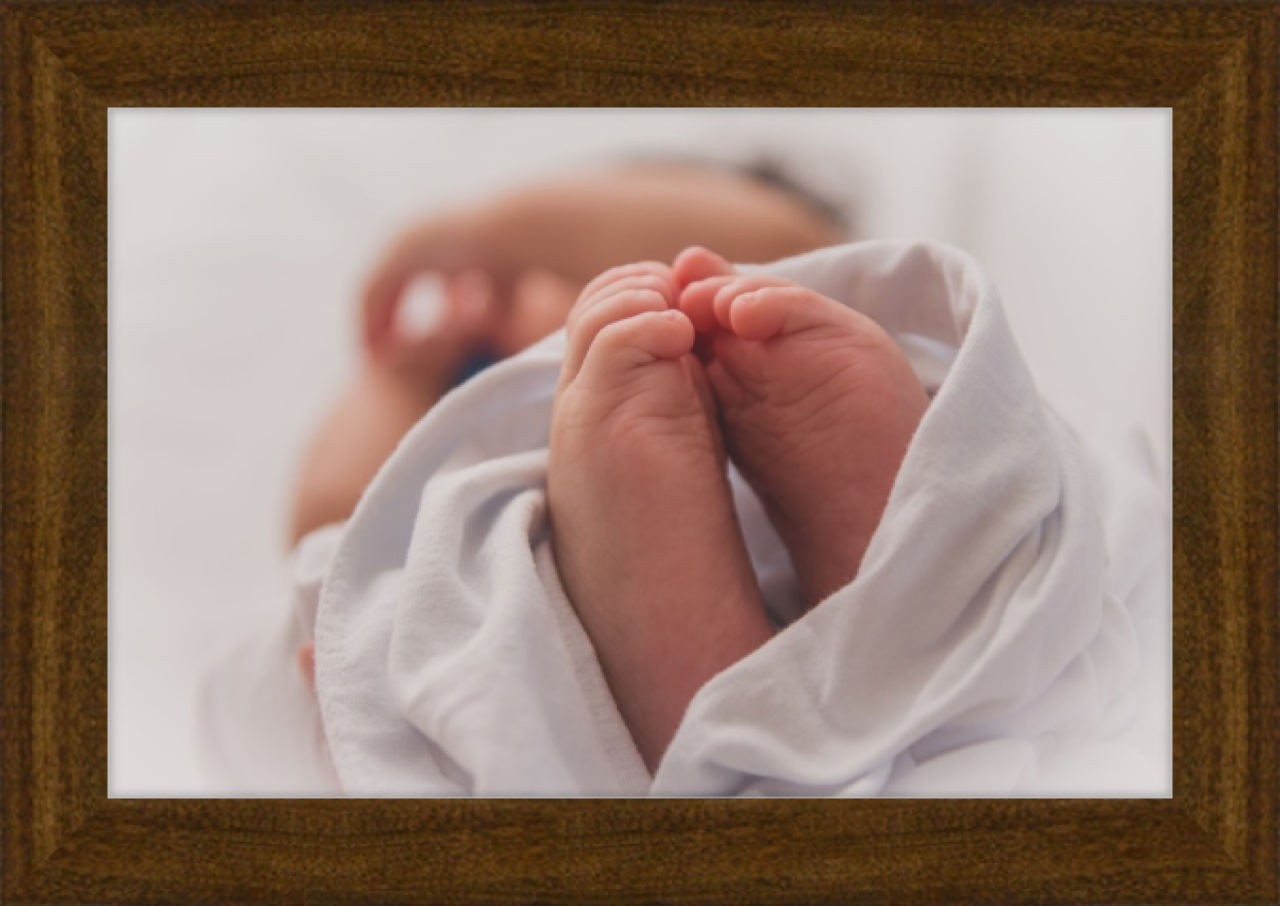 Dark wood frame around newborn photo 