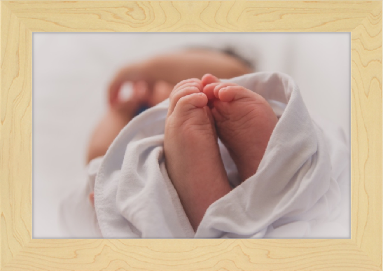 Light wood frame around newborn photo 