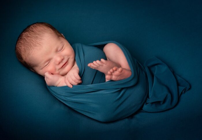 Newborn Baby Photo Ideas: A smiling baby in a swaddle