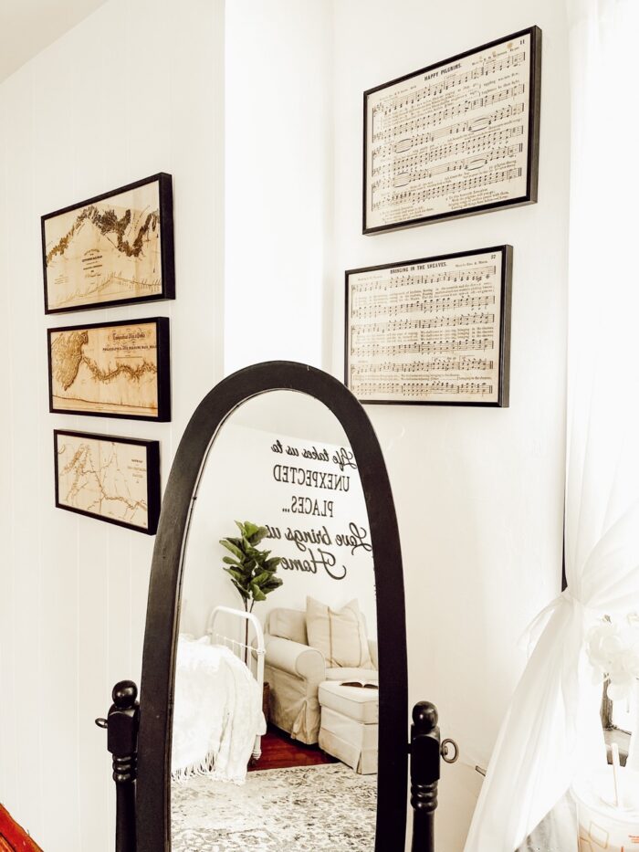 A room with framed maps, mountain ranges, and sheet music. 