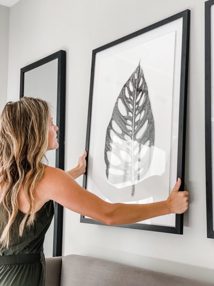 A woman hanging Black Picture Frames