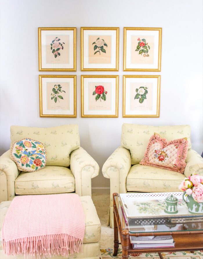 Gold frames with art prints above chairs