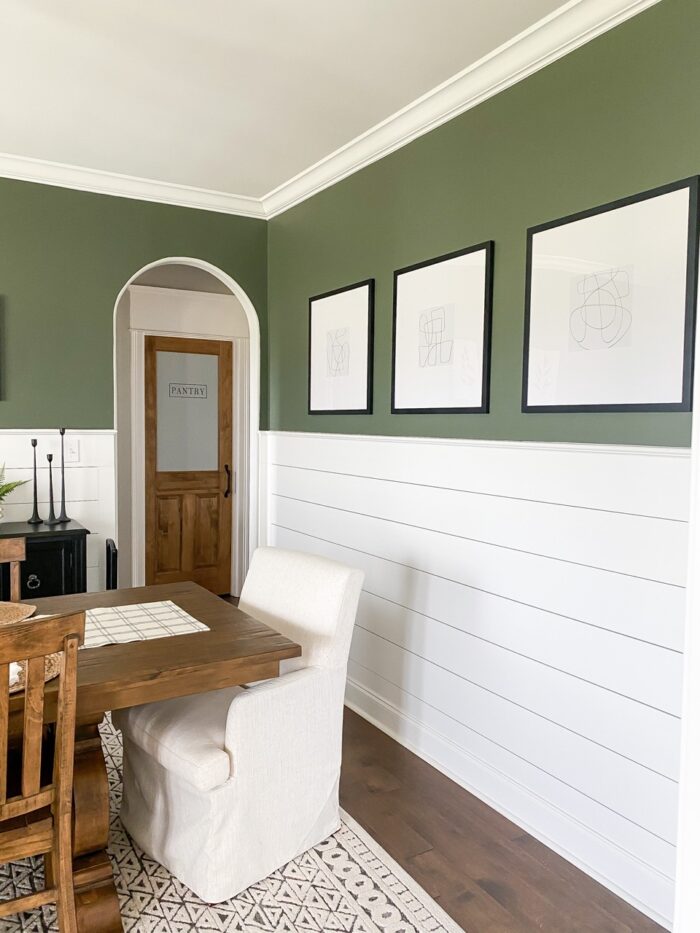 Framed art prints in a green dining room