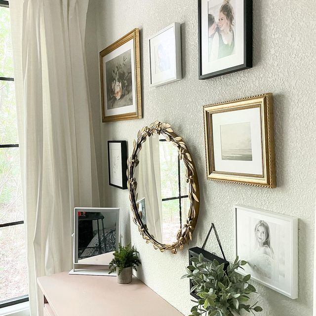 Framed pictures and a mirror with a staggered gallery wall.