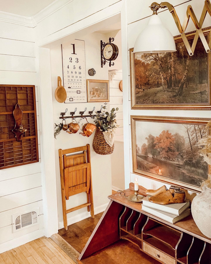 Cottagecore style office with vintage furniture and framed art prints.