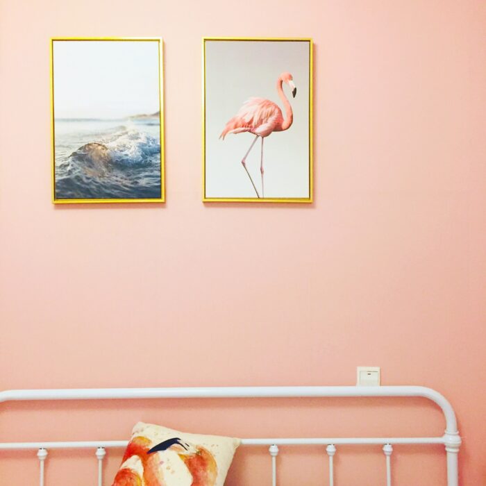 Pink room with gold framed pictures in an airbnb.