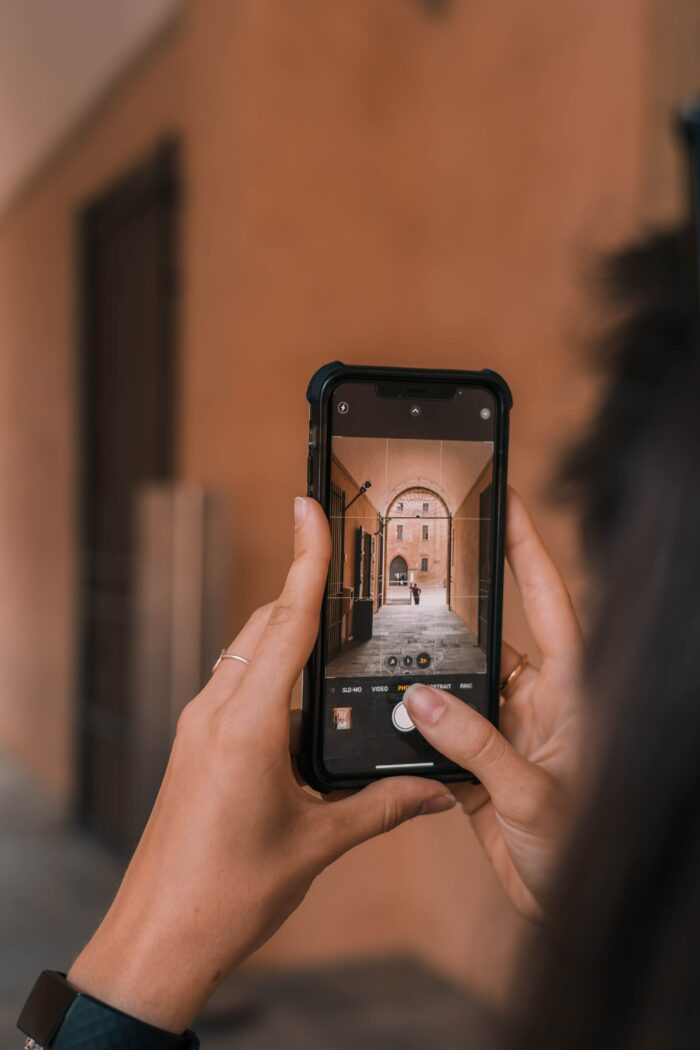 How to Take Professional Headshots: Taking a photo with a phone in an alley.