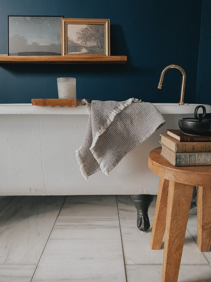 Victorian & Gothic Home Decor Guide: A dark blue bathroom with a shelf gallery wall.