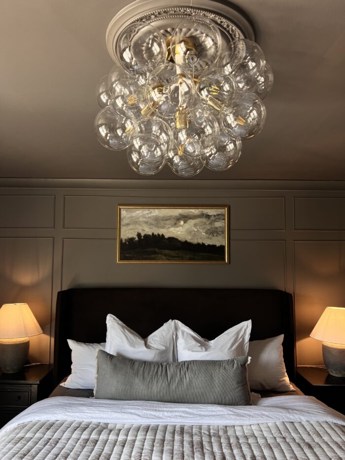 Victorian & Gothic Home Decor Guide: A dark gray bedroom paired with a Granby gold frame and a modern chandelier.  