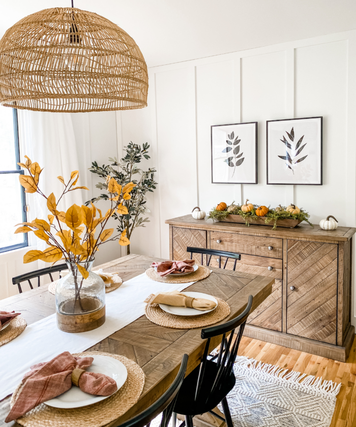 A cozy fall aesthetic with pumpkins and gourds in a dining room.