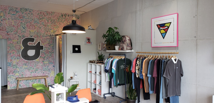 Waiting room design with framed art print above a clothing rack. 