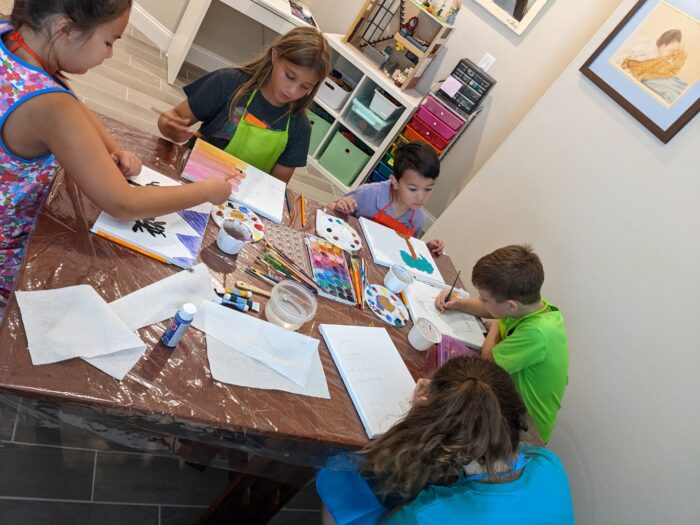 Framing children's art: Kids work on their paintings at the studio.