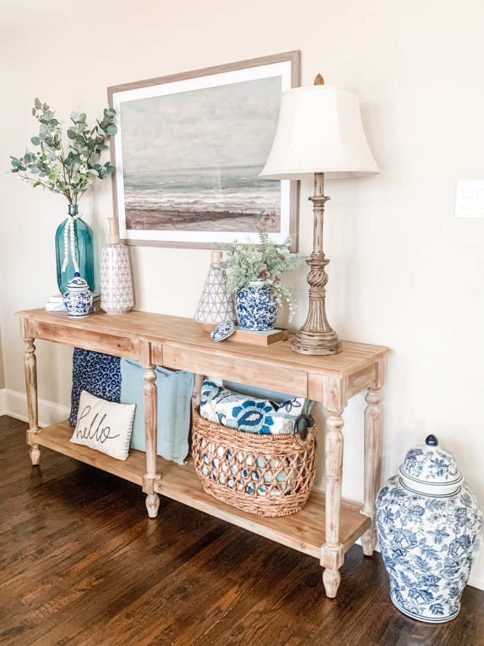 Nautical decor with framed artwork, pottery, and a lamp.