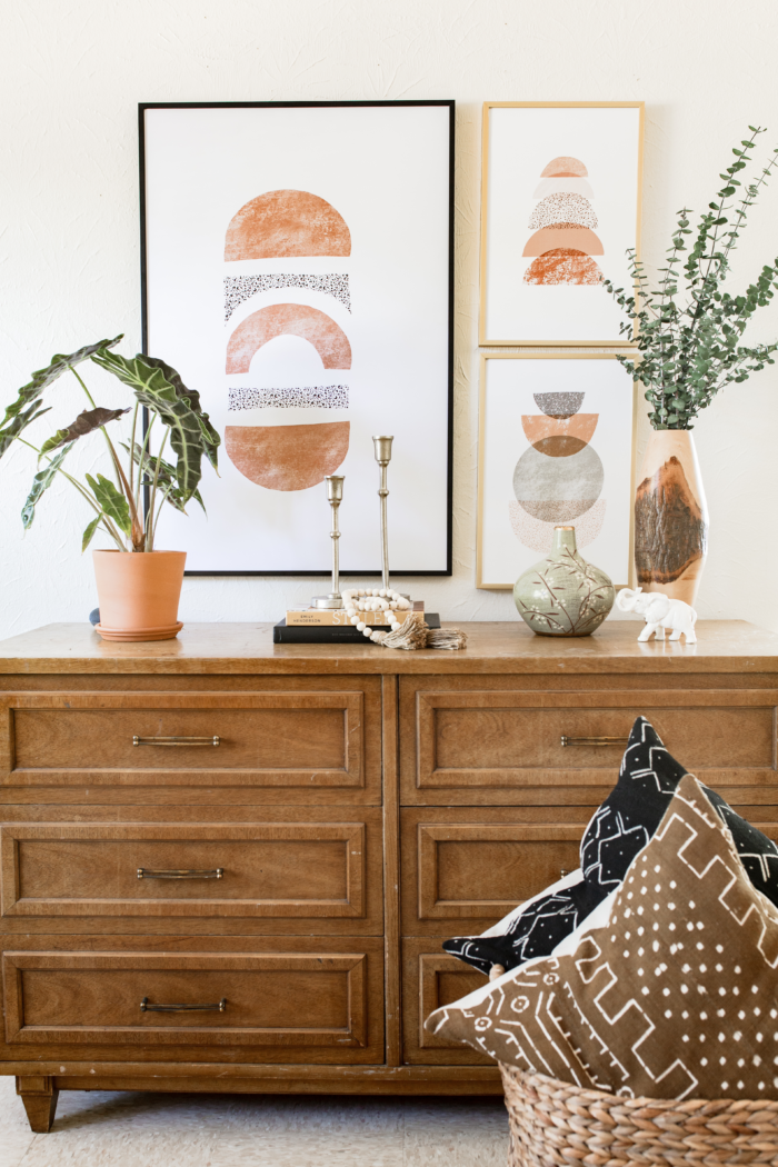 Bohemian decor with a dresser, framed art prints, and plants.
