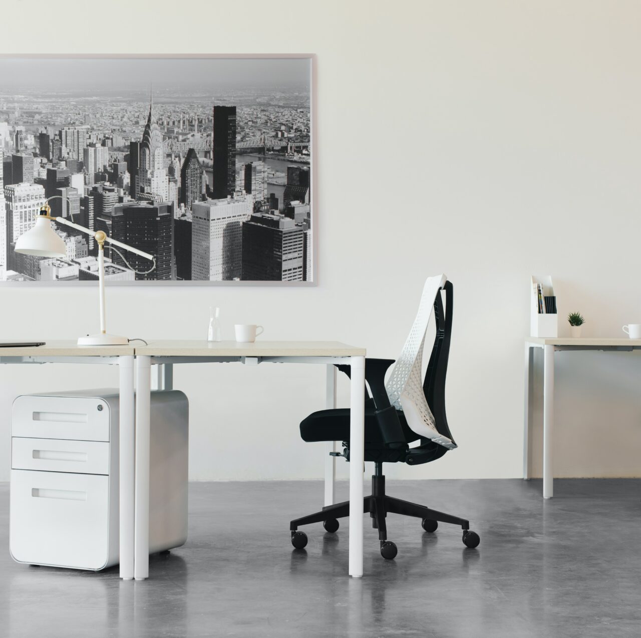 Modern office decor with white chair and framed city print.