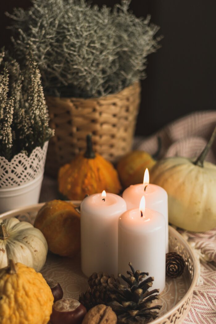 A cozy fall aesthetic with candles and pumpkins.