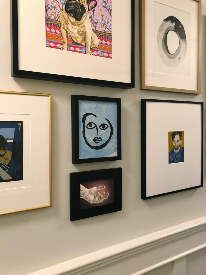 Different artworks and prints on a gallery wall.