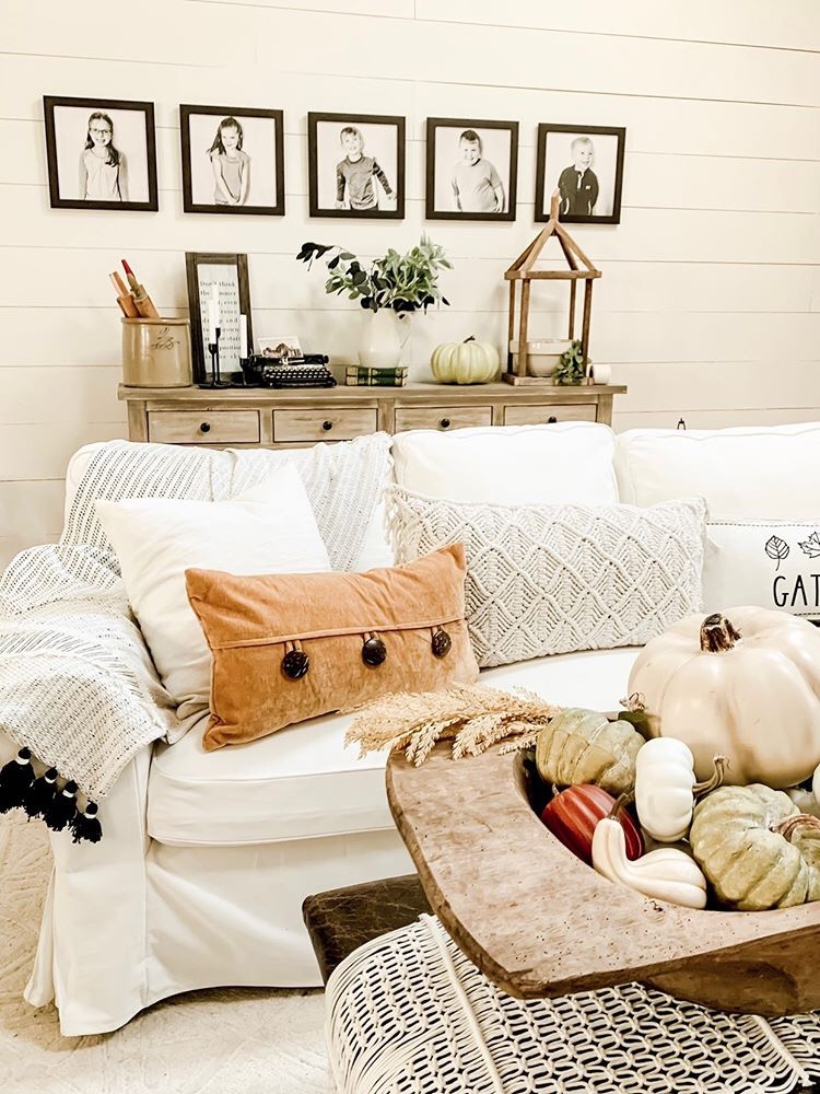 Cozy Fall Aesthetic: Fall-inspired room with framed photos above a couch.