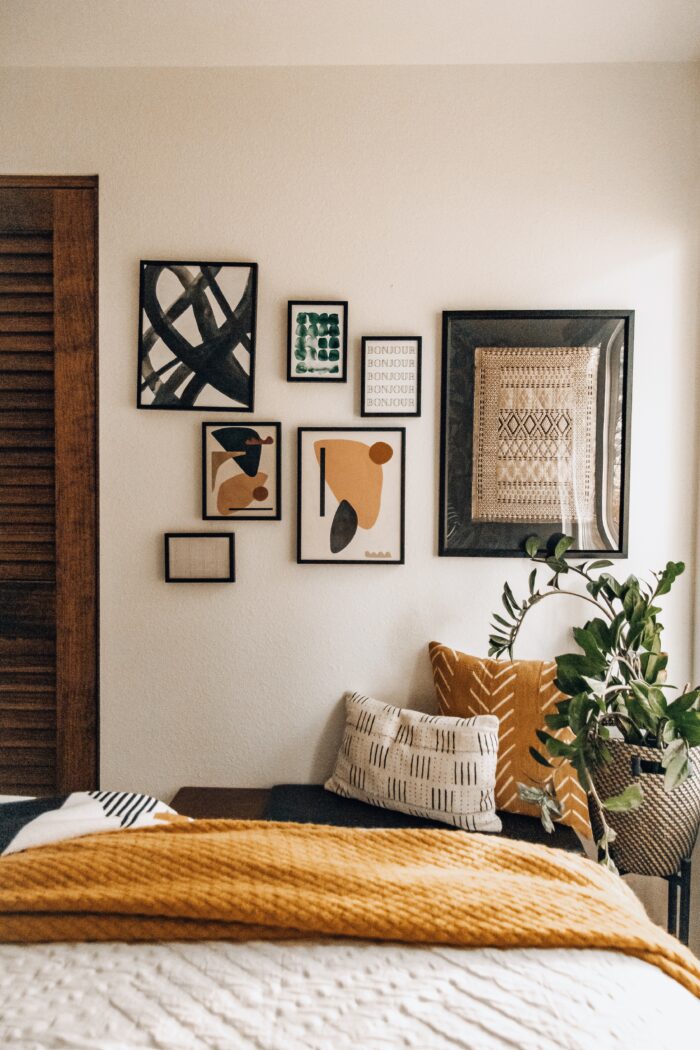 Alternative Living & Functional Framing: A boho-styled bedroom with a small gallery wall with different frame sizes. 