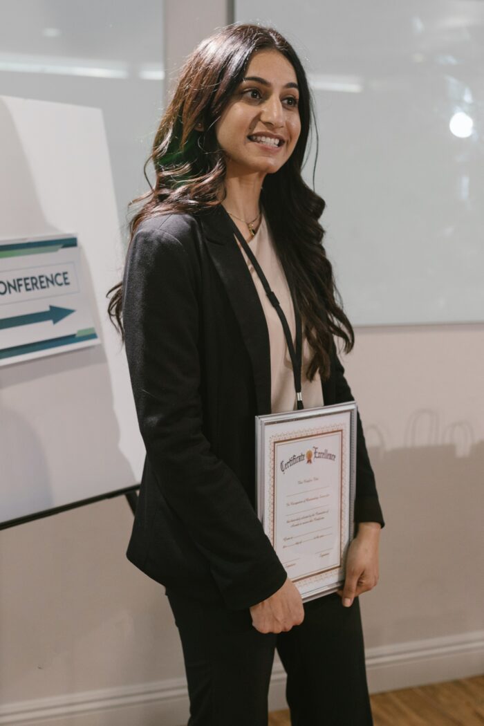 A lady holding an achievement certificate or a certificate of completion 