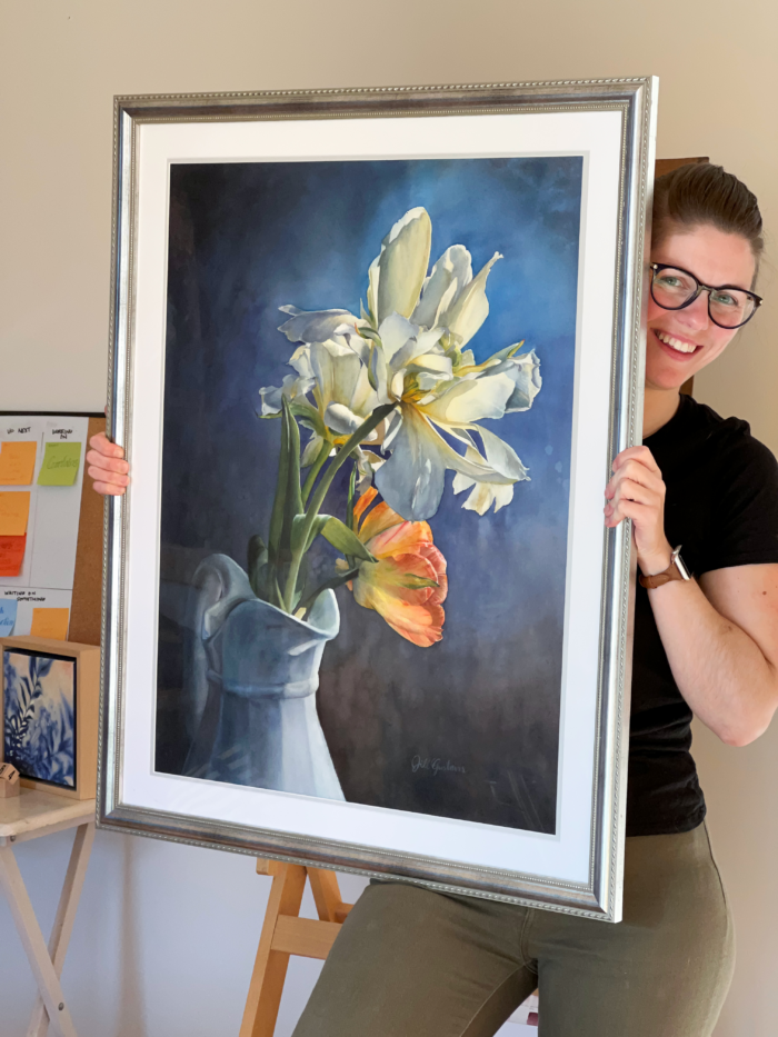 A lady holding a framed art print